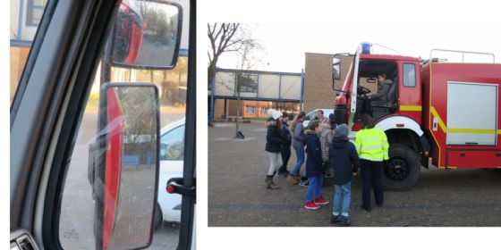 Aktion Toter Winkel. Kinder stehen vor einem großen Feuerwehr-Auto. 