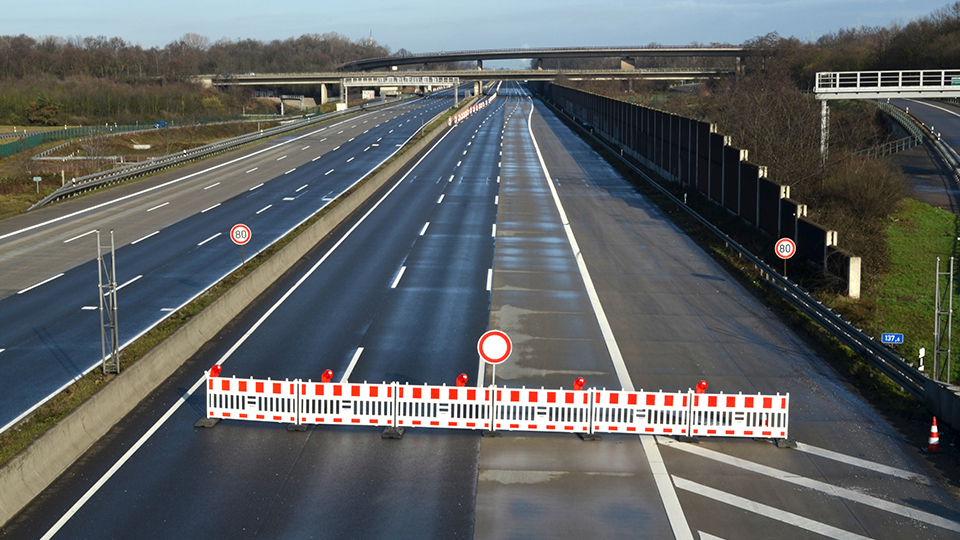 Das Symbolbild Autobahnsperrung zeigt eine Absperrung im Vordergrund eine leere Autobahn im Hintergrund
