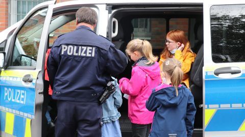 Kinder schauen einen Streifenwagen an. 