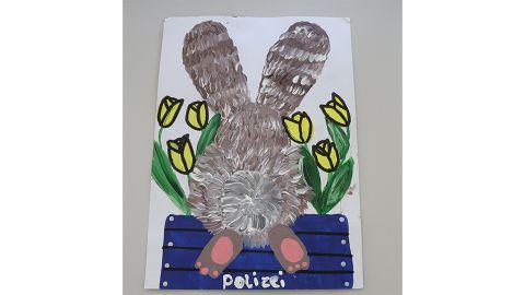Das Kinderbild zeigt einen Hasen und Blumen