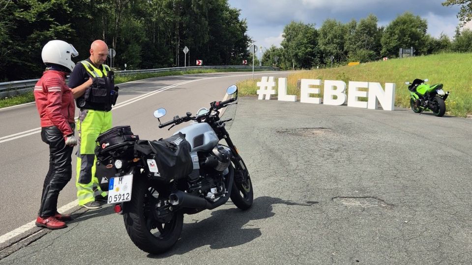 Biker im Gespräch mit einer Fachkraft des VD bei Aktion Hashtag LEBEN in der Applauskurve